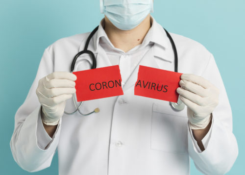 Lekarz trzymający przerwany napis Koronawirus.