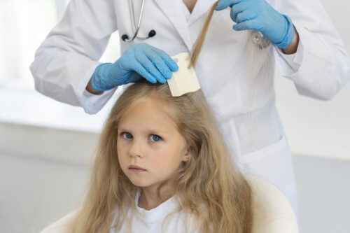 lekarz bada włosy dziecka